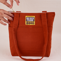 Over-Shoulder Zip Mini Tote in Paprika with model holding zipper