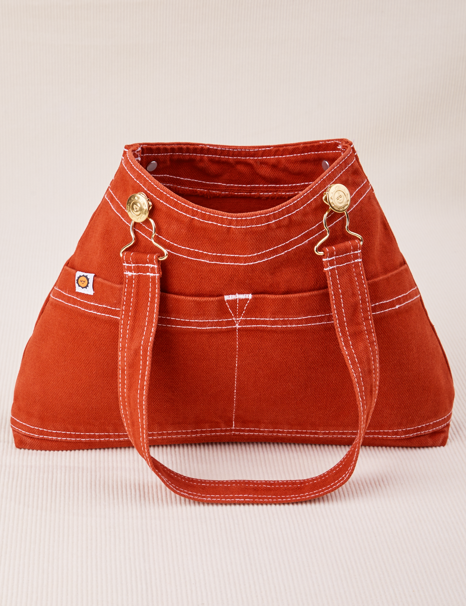 Overall Handbag in Paprika with one strap laying down the front