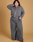 Ashley is wearing a zipped up Heritage Mechanic Jacket in Washed Grey paired with matching Wide Leg Trousers