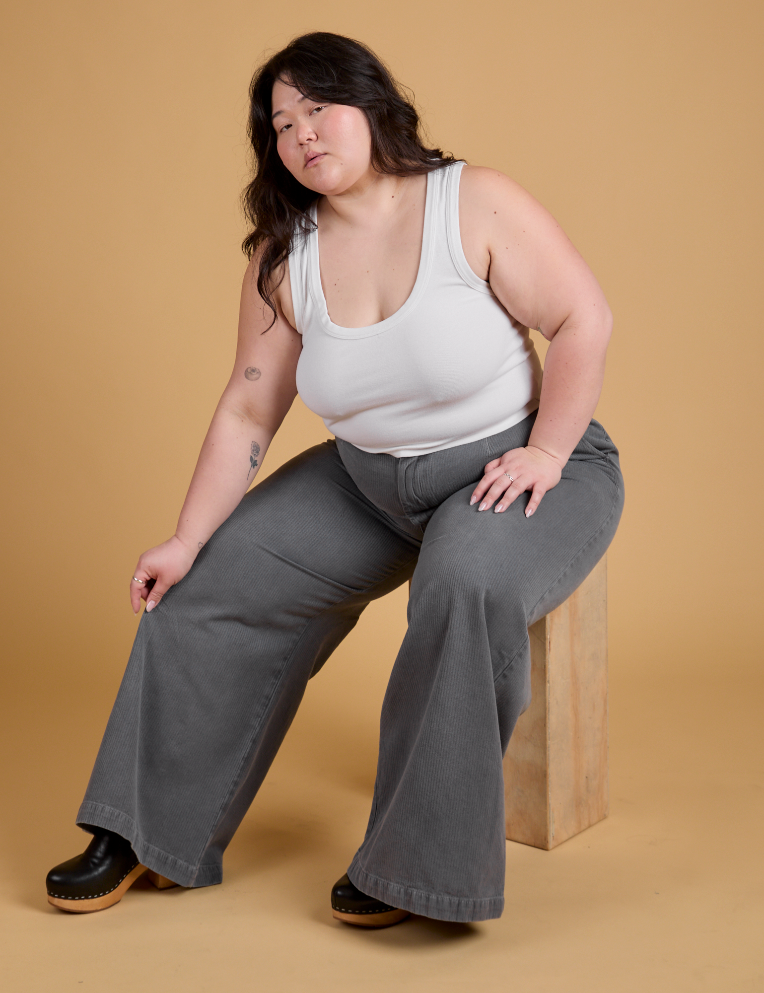 Ashley is wearing Heritage Wide Leg Trousers in Washed Grey and vintage tee white Cropped Tank