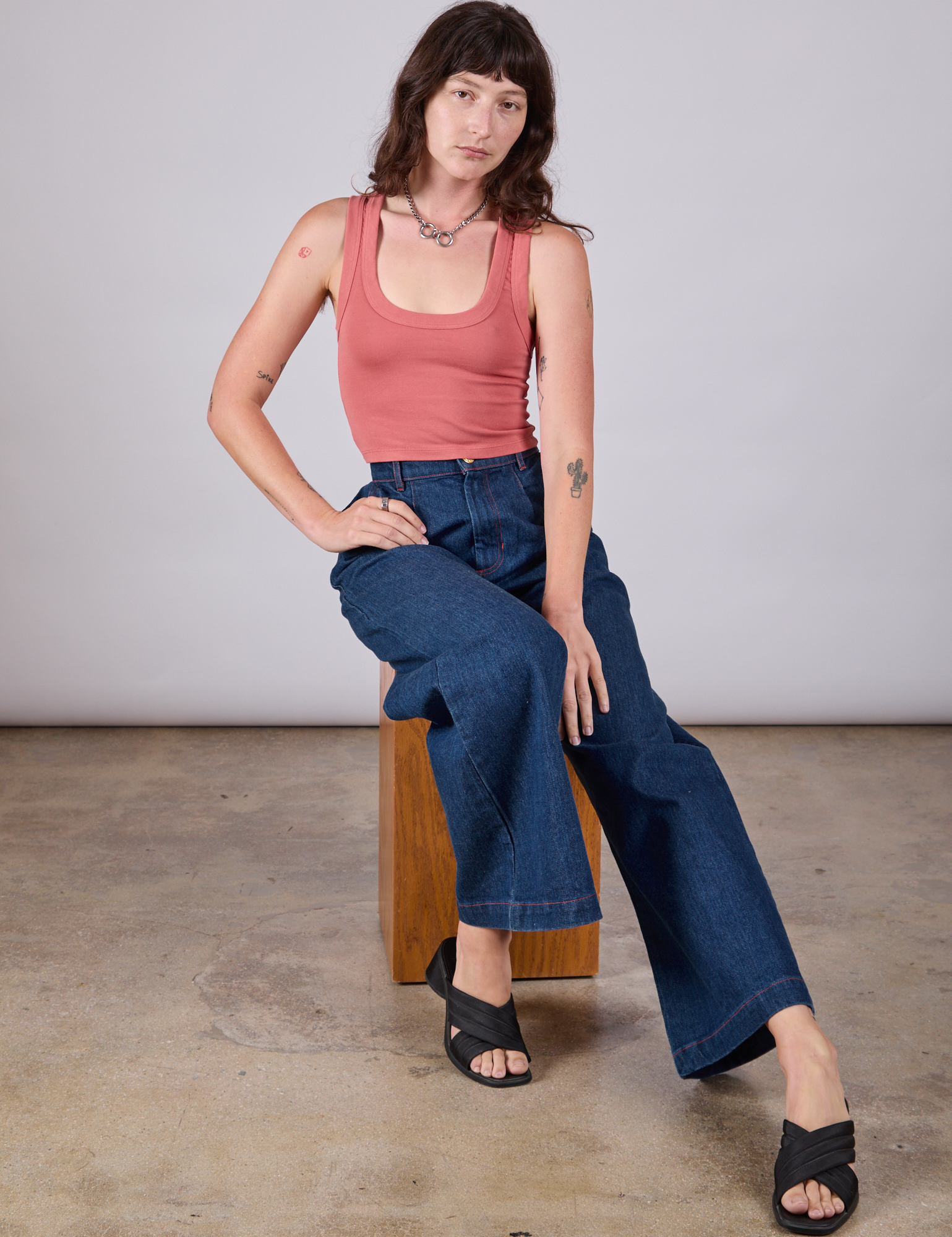 Alex is wearing Cropped Tank Top in Raspberry Sorbet and dark wash Wide Leg Denim Trousers