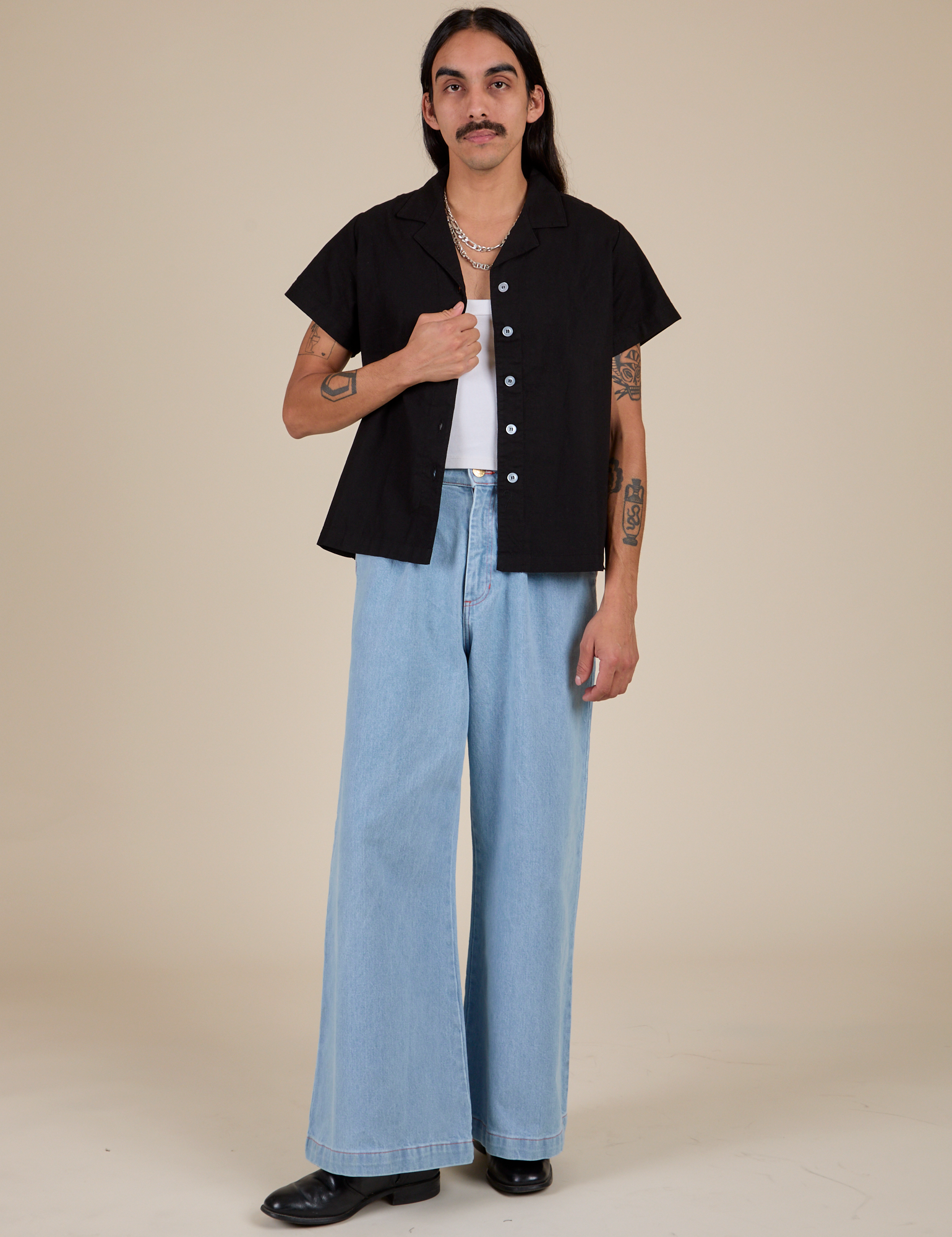 Anthony is wearing Pantry Button-Up in Basic Black and light wash Indigo Wide Leg Trousers