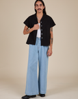 Anthony is wearing Pantry Button-Up in Basic Black and light wash Indigo Wide Leg Trousers