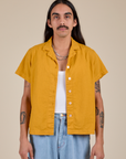 Anthony is 5’6” and wearing S Pantry Button-Up in Mustard Yellow
