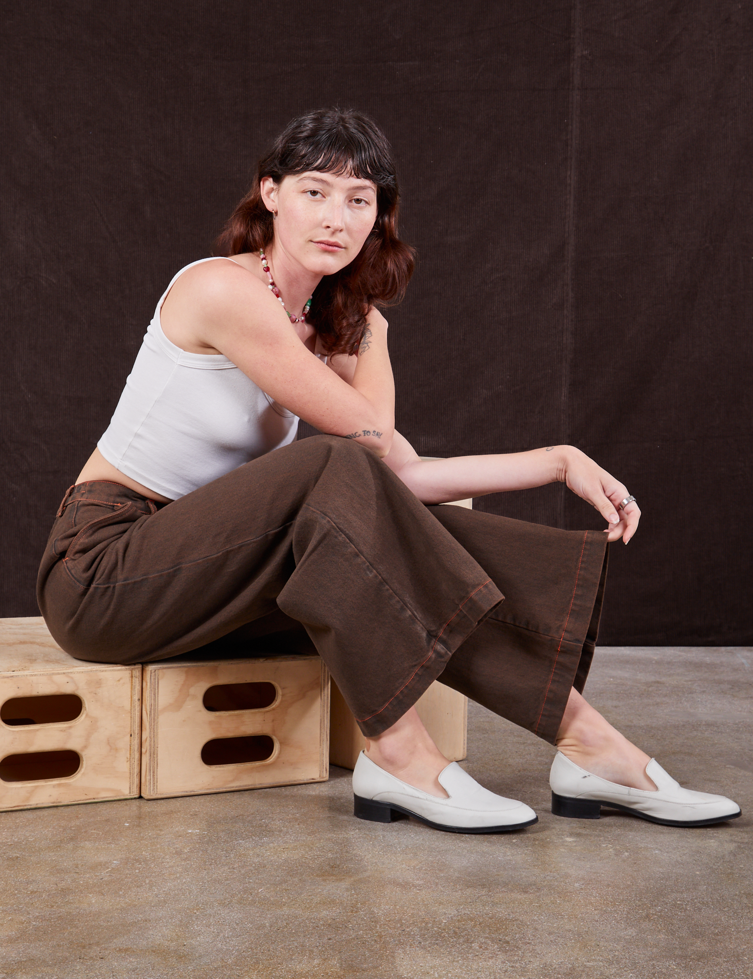 Alex is wearing Overdyed Wide Leg Trousers in Brown and vintage off-white Cami