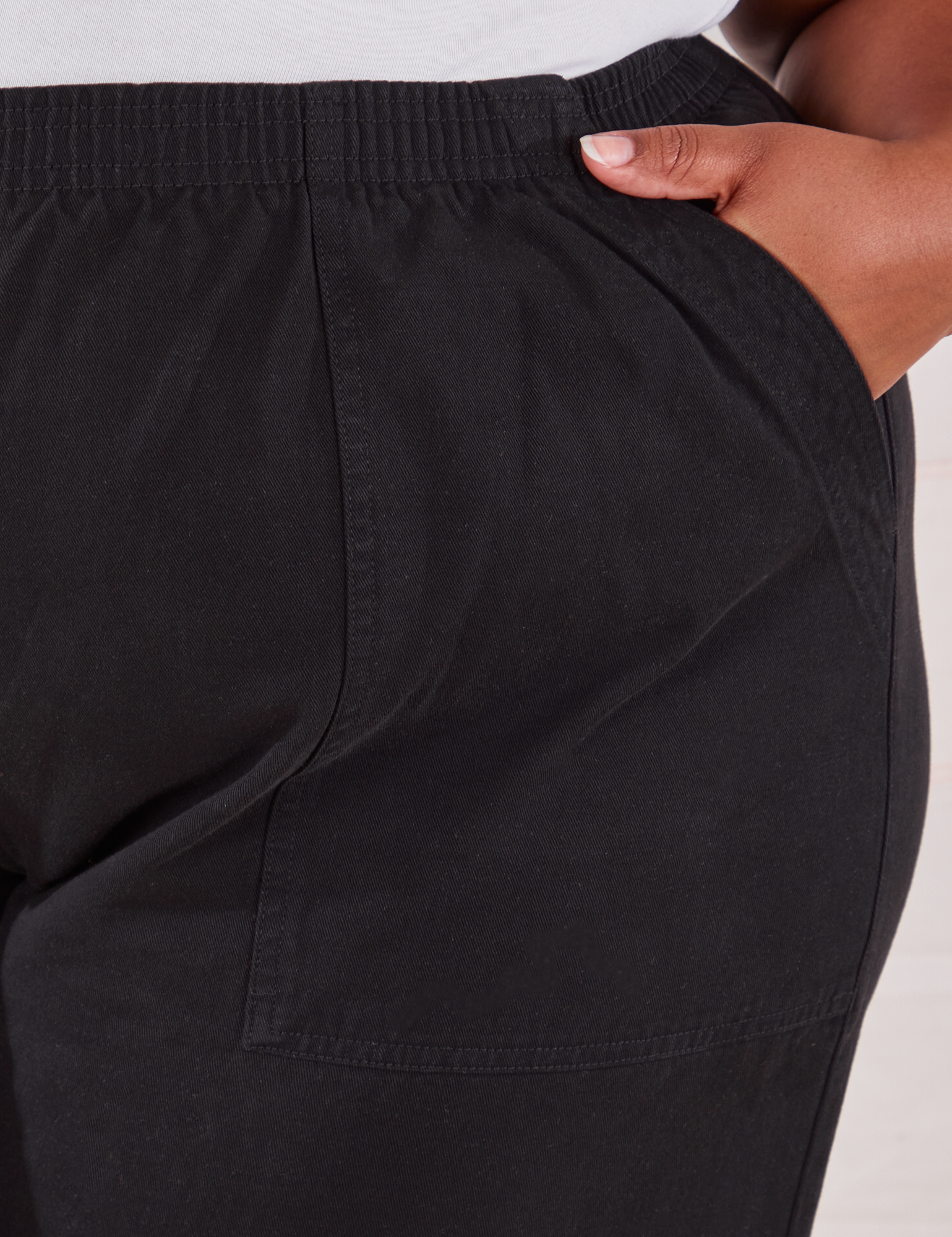 Action Pants in Basic Black front pocket close up. Morgan has her hand in the pocket.