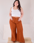 Ashley is 5'7" and wearing 1XL Bell Bottoms in Burnt Terracotta paired with a Cropped Tank in vintage tee off-white