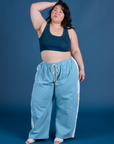 Ashley is 5’7” and wearing 1XL Painted Drop Pocket Cargo Pants in Baby Blue paired with lagoon Mini Tank