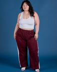 Ashley is 5’7” and wearing 1XL Painted Action Pants in Red Wine paired with vintage tee white Cropped Tank
