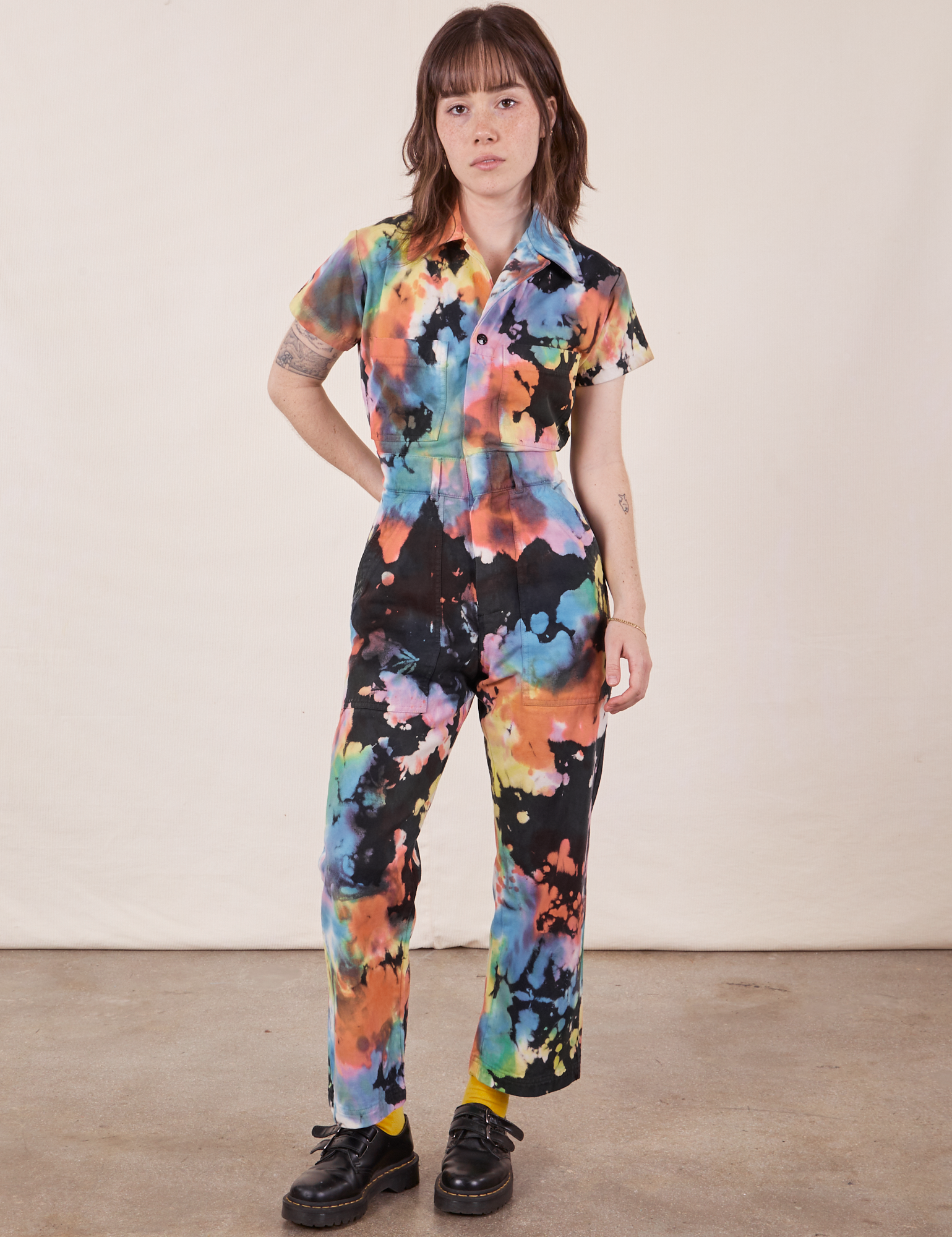 Hana is 5&#39;3&quot; and wearing XXS Petite Petite Short Sleeve Jumpsuit in Rainbow Magic Waters