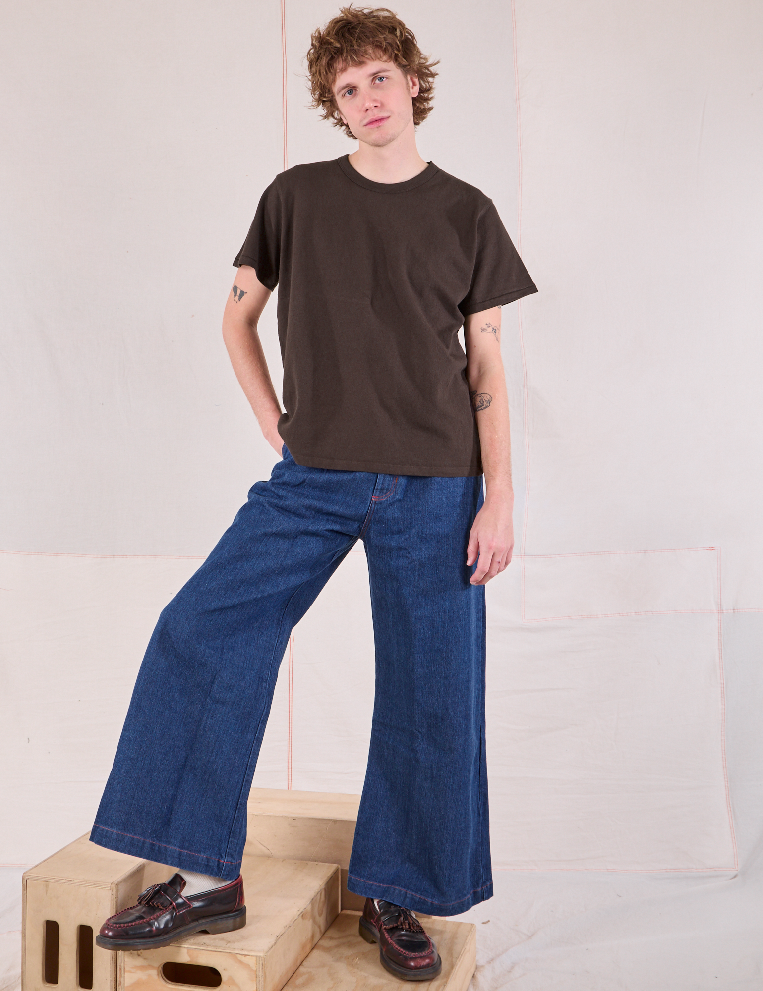 Quinn is wearing Burly Tee in Espresso Brown paired with dark wash Denim Wide Leg Trousers