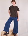 Quinn is wearing Burly Tee in Espresso Brown paired with dark wash Denim Wide Leg Trousers