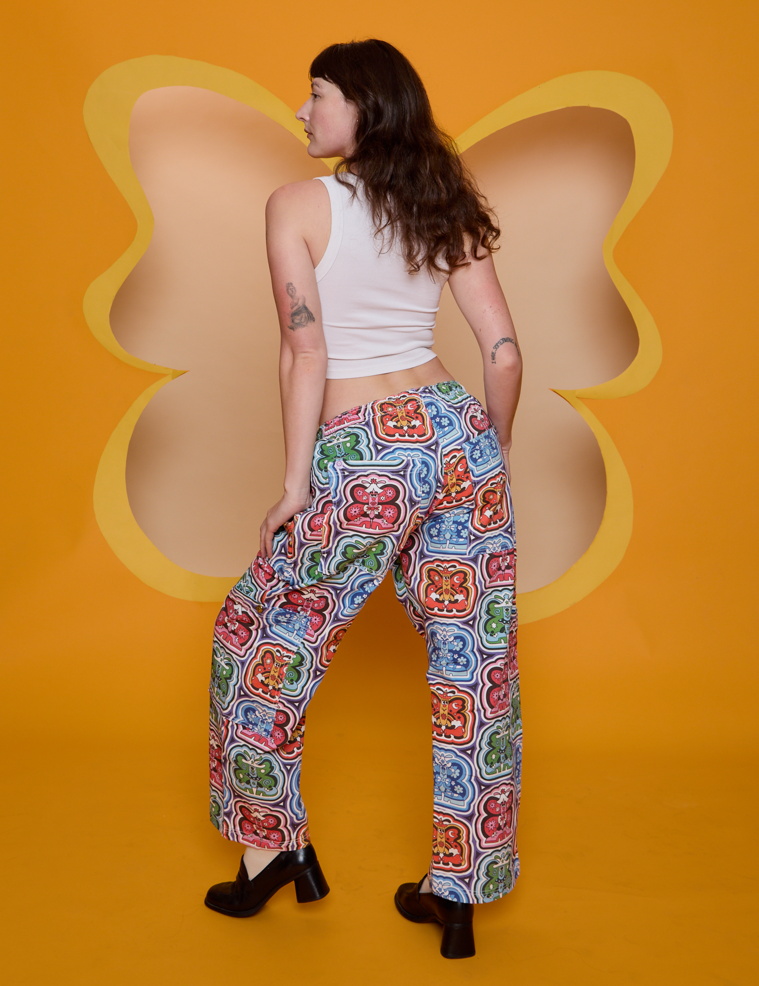 Back view of Butterfly Kaleidoscope Drop Pocket Cargo Pants and Cropped Tank in Vintage Tee White on Alex