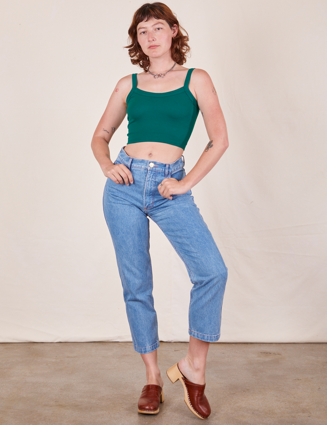 Alex is wearing Cropped Cami in Hunter Green and light wash Frontier Jeans