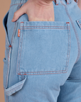Close up of Alex's hand in the back pocket of Carpenter Jeans in Light Wash