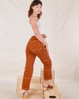 Angled back view of Carpenter Jeans in Burnt Terracotta on Alex