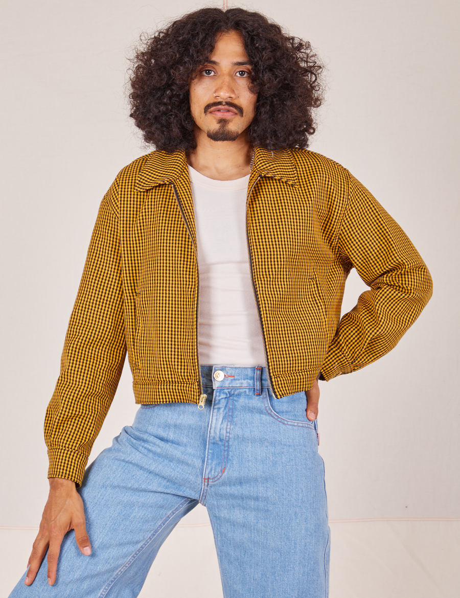 Jesse is 5'8" and wearing XS Ricky Jacket in Checker Yellow paired with light wash Sailor Jeans
