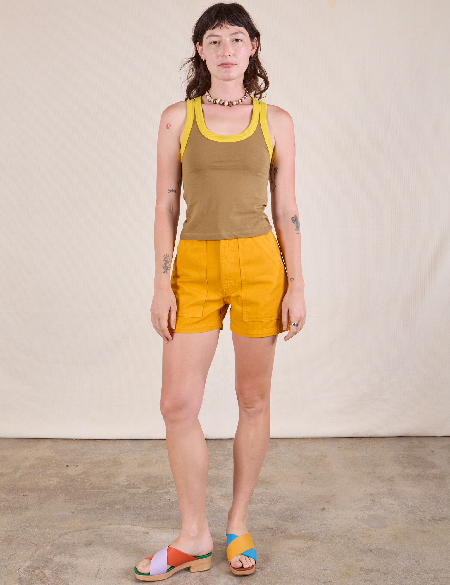 Alex is wearing Colorblock Cropped Tank in Desert Brown and mustard yellow Work Shorts