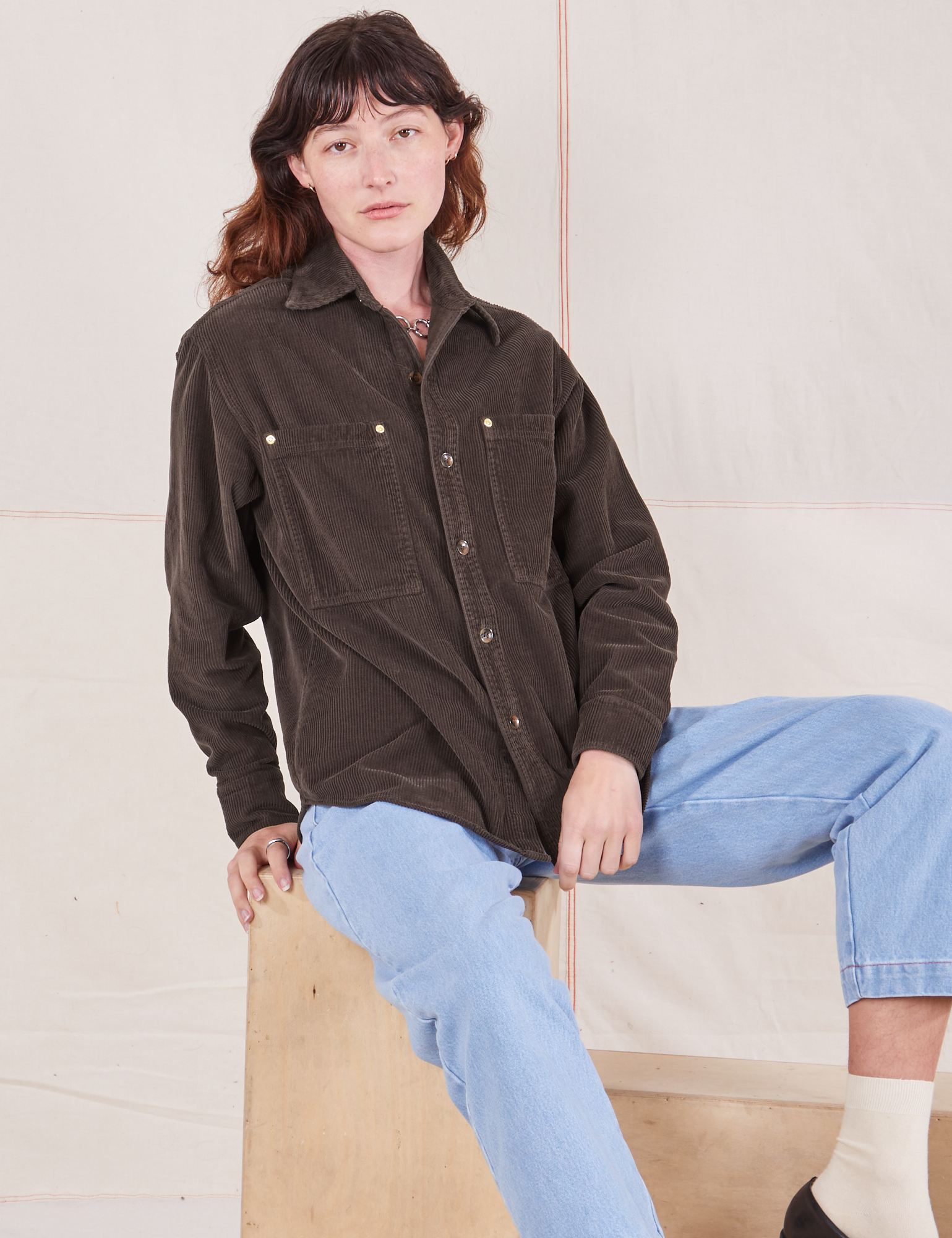 Alex is wearing a buttoned up Corduroy Overshirt in Espresso Brown and light wash Denim Trouser Jeans