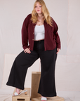 Juliet is wearing Cropped Overshirt in Red Wine and basic black Bell Bottoms