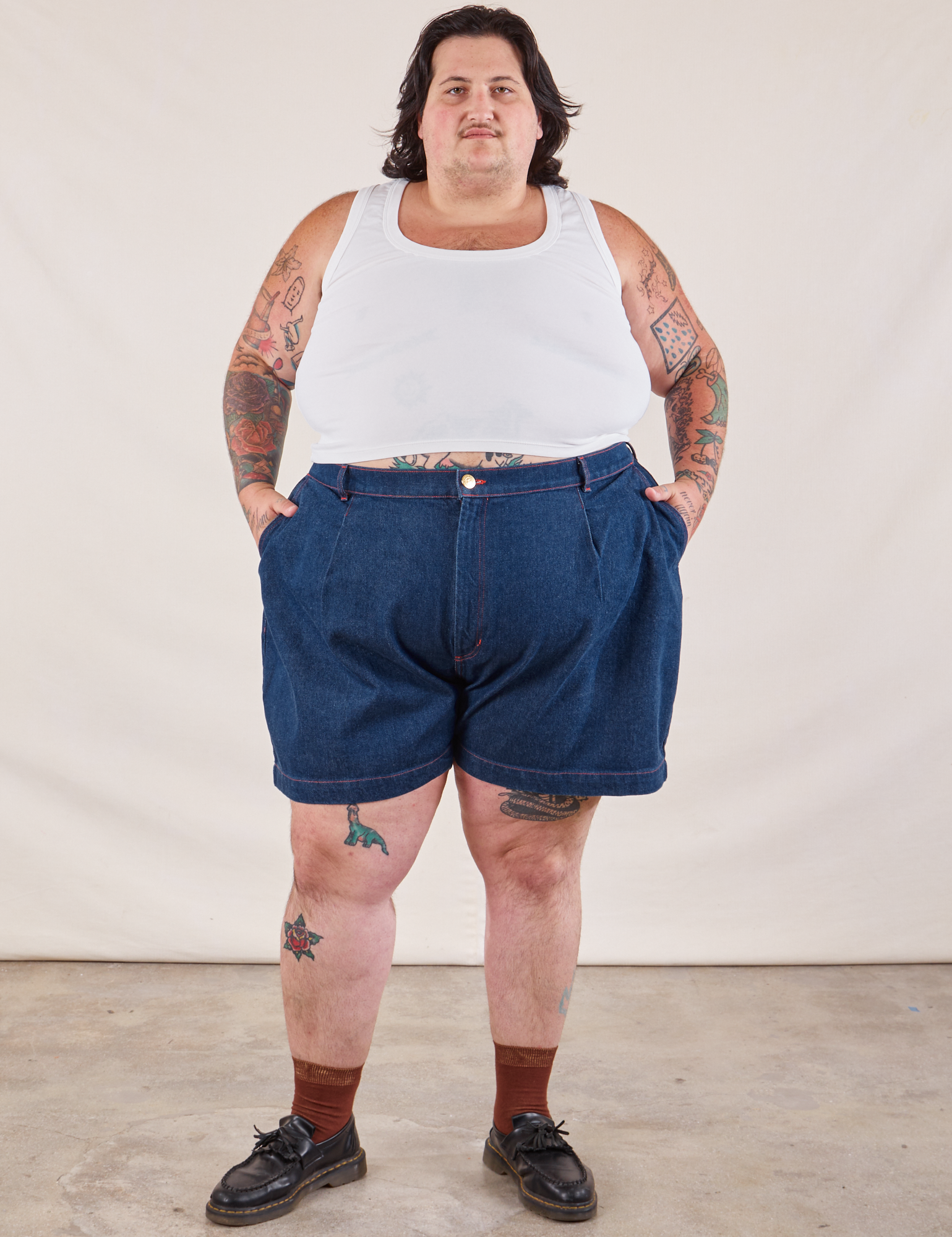 Sam is 5&#39;10” and wearing 3XL Denim Trouser Shorts in Dark Wash paired with a Cropped Tank in vintage tee off-white