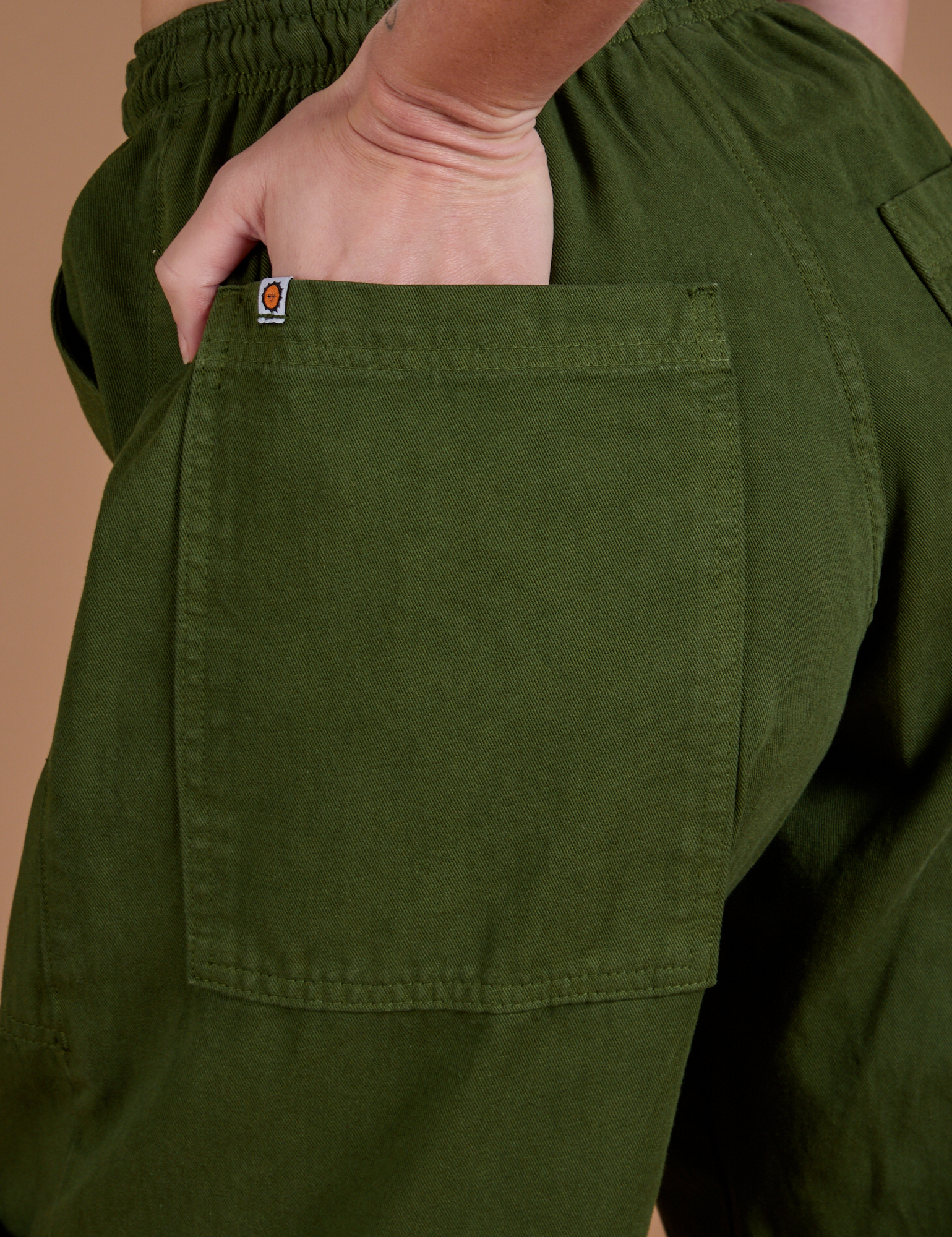 Close up of Alex&#39;s hand in the back pocket of Drop Pocket Cargo Pants in Evergreen