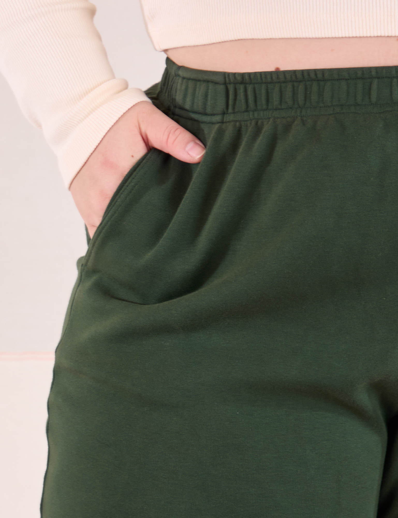 Easy Pants in Swamp Green front pocket close up. Ashley has her hand in the pocket.