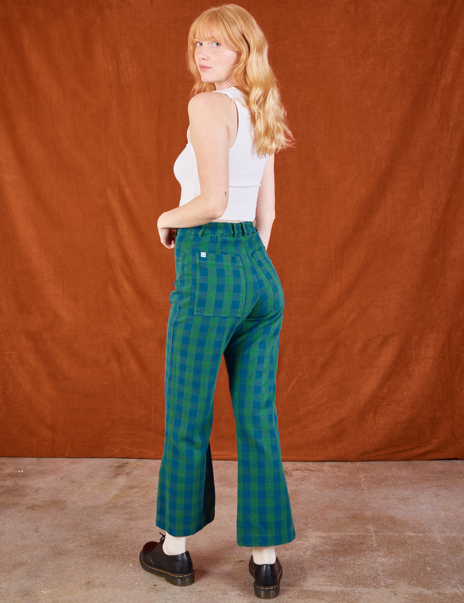 Angled back view of Gingham Western Pants in Green and Cropped Tank in vintage tee off-white on Margaret