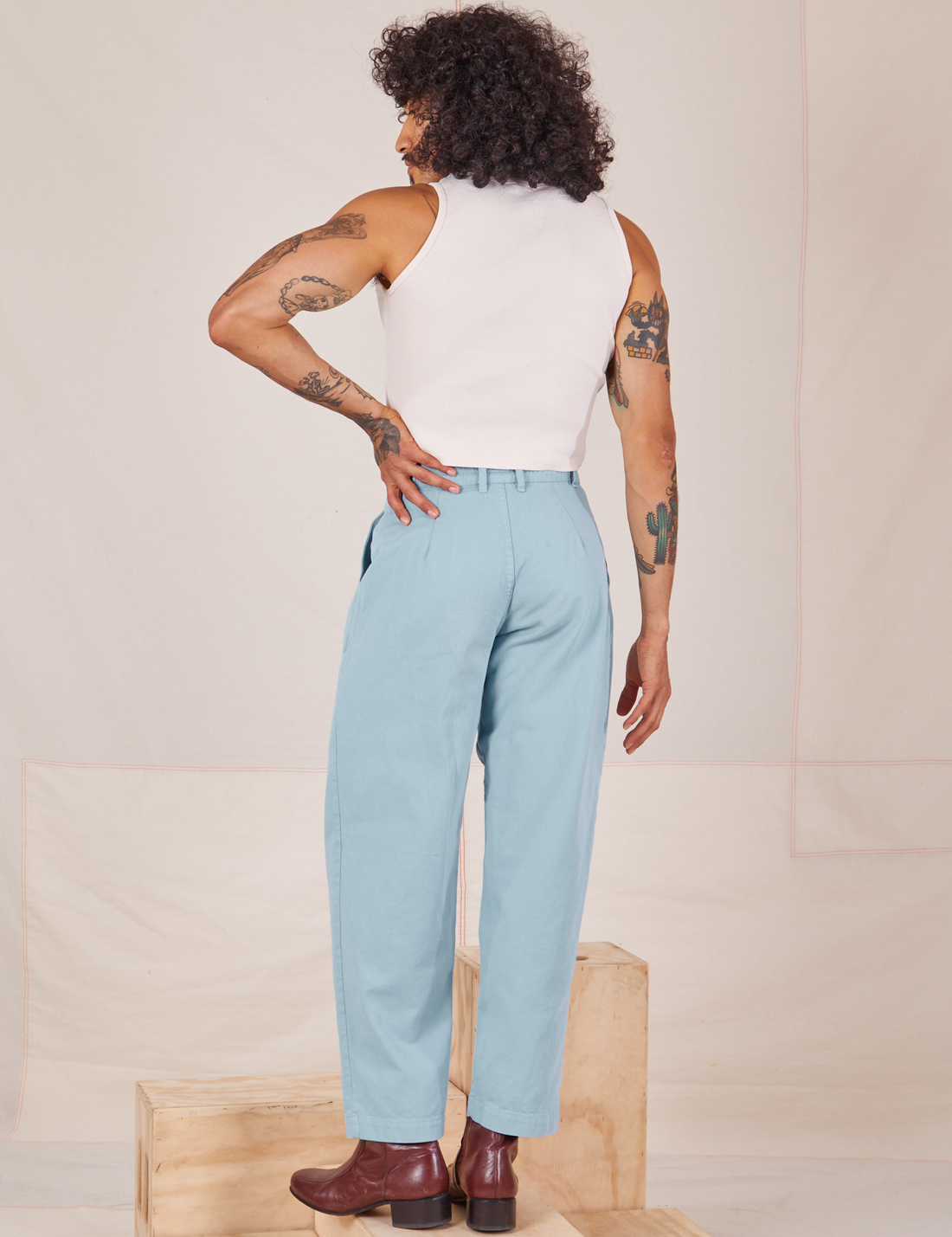 Back view of Heavyweight Trousers in Baby Blue and vintage off-white Sleeveless Turtleneck worn by Jesse