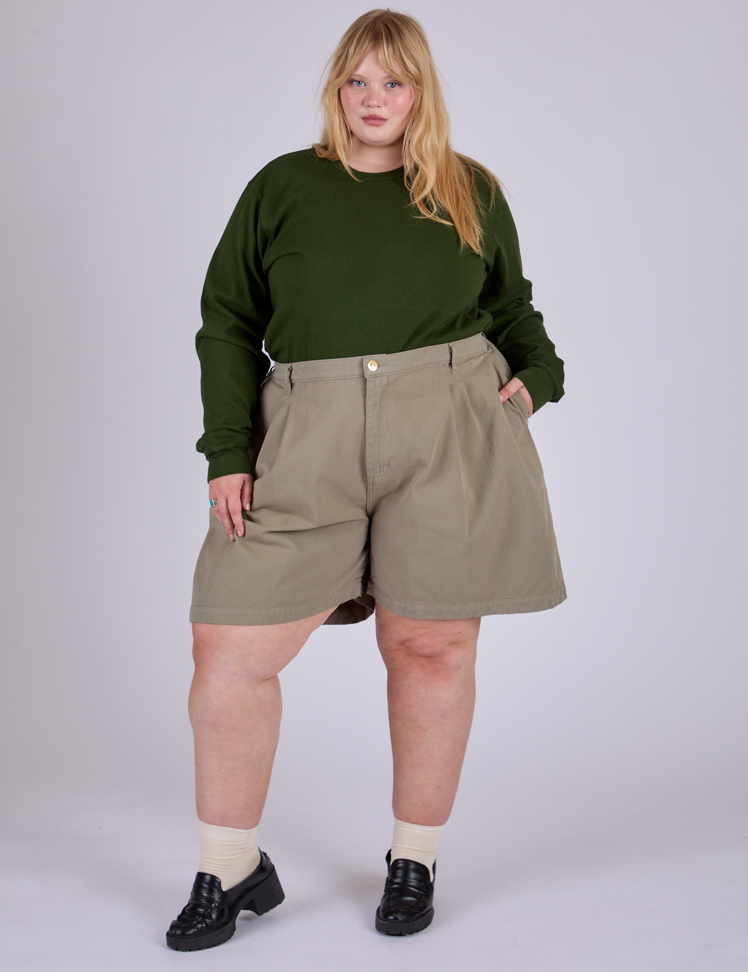 Juliet is 5’7” and wearing 2XL Pleated Trouser Shorts in Khaki Grey paired with evergreen Long Sleeve Burly Tee