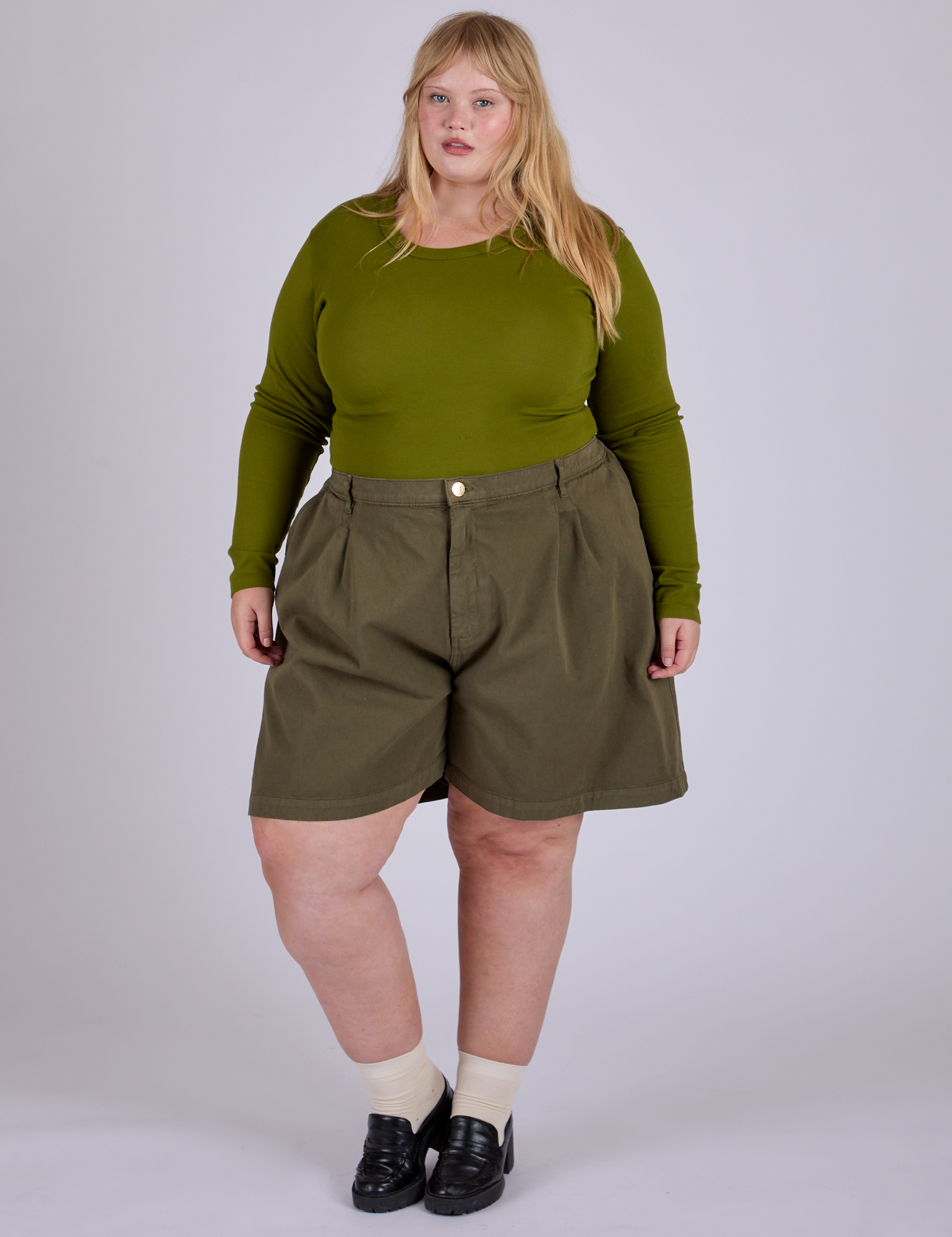Juliet is 5’7” and wearing 2XL Pleated Trouser Shorts in Surplus Green paired with summer olive Long Sleeve Baby Tee