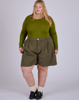 Juliet is 5’7” and wearing 2XL Pleated Trouser Shorts in Surplus Green paired with summer olive Long Sleeve Baby Tee
