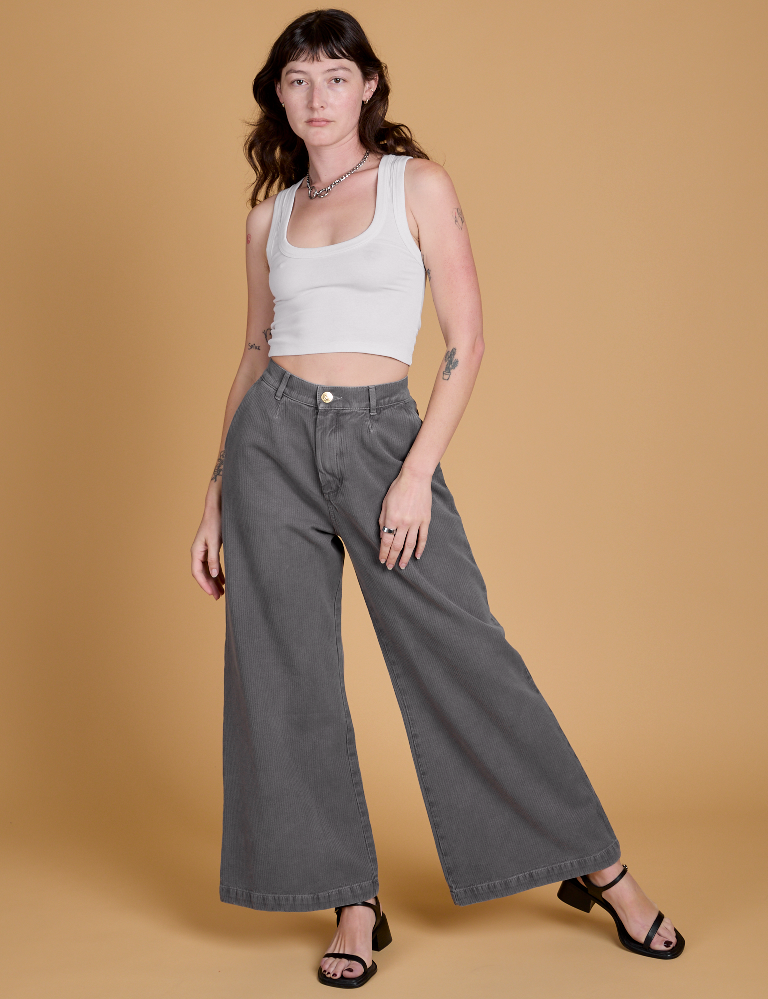 Alex is 5&#39;8&quot; and wearing XXS Heritage Wide Leg Trousers in Washed Grey paired with a vintage tee white Cropped Tank