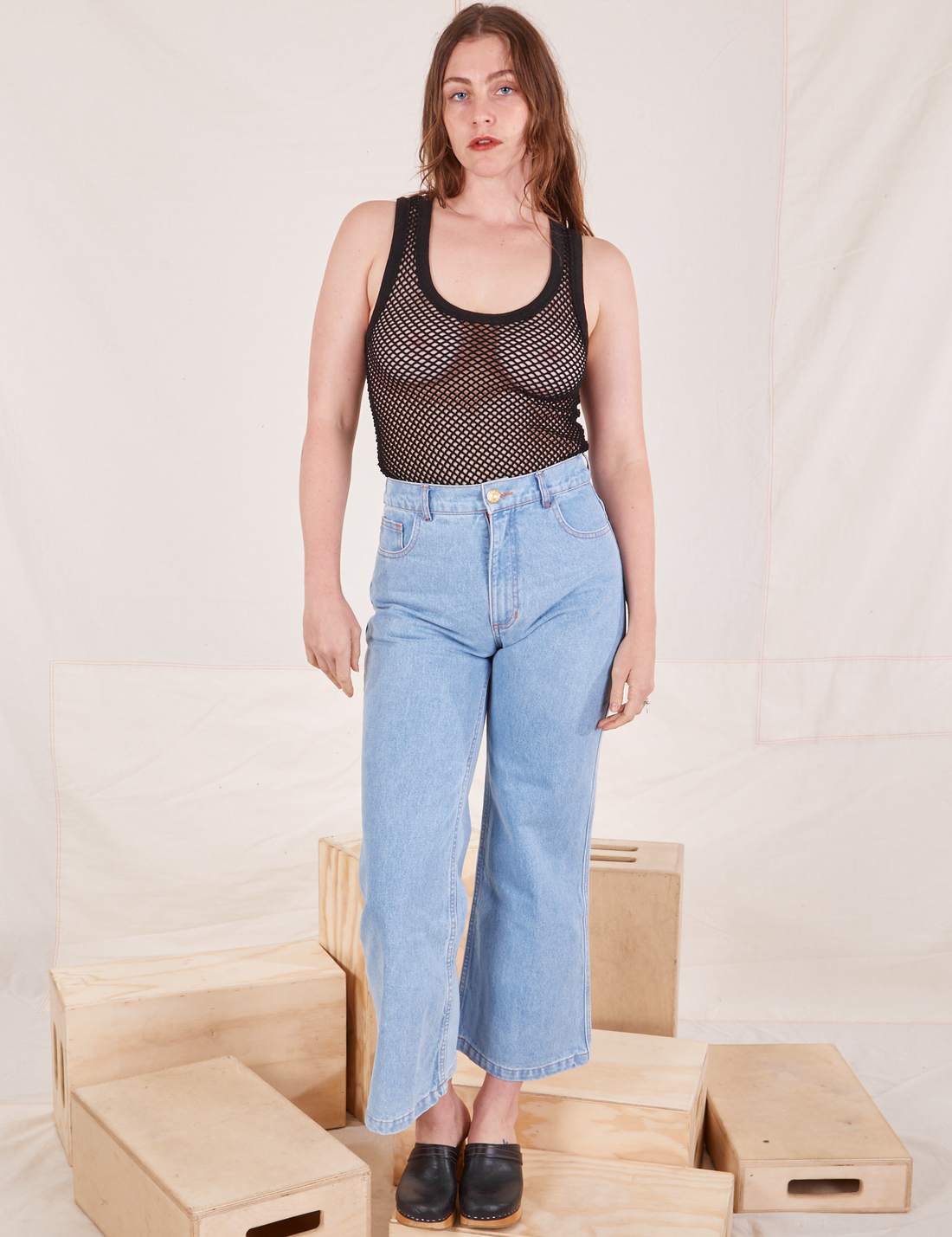 Allison is 5'10 and wearing XXS Mesh Tank Top in Basic Black paired with light wash Sailor Jeans