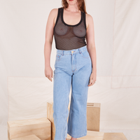 Allison is 5'10 and wearing XXS Mesh Tank Top in Basic Black paired with light wash Sailor Jeans