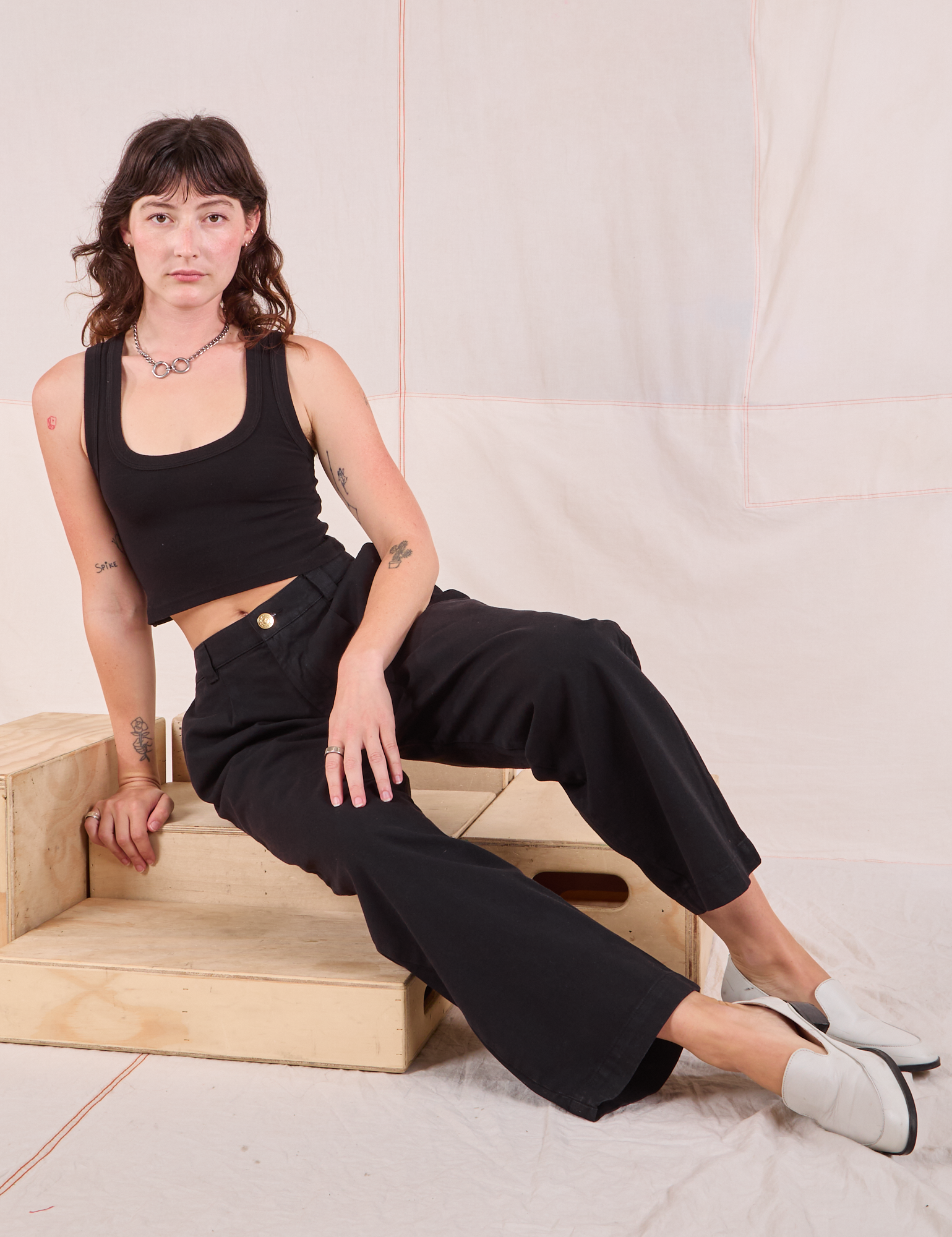 Alex is wearing Mid-Rise Pleated Trousers in Basic Black and black Cropped Tank