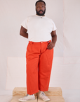 Elijah is 6'3" and wearing 1XL Mid-Rise Pleated Trousers in Chili Red paired with Organic Vintage Tee in Vintage Tee Off-White