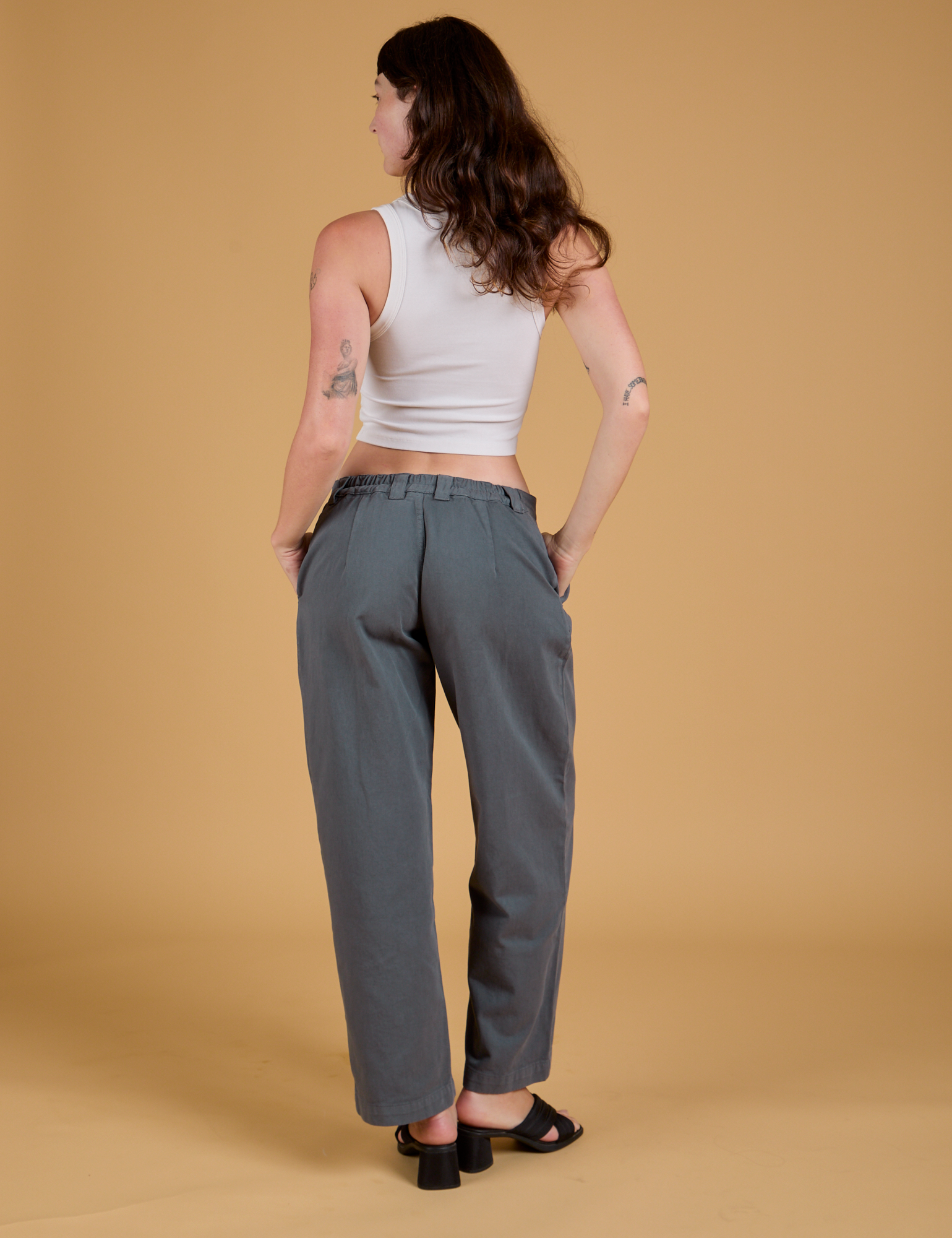 Back view of Baggy Mid-Rise Trousers in Slate Grey and vintage tee white Cropped Tank on Alex