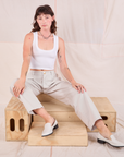 Alex is wearing Mid-Rise Pleated Trousers in Stone White and Cropped Tank in vintage tee off-white