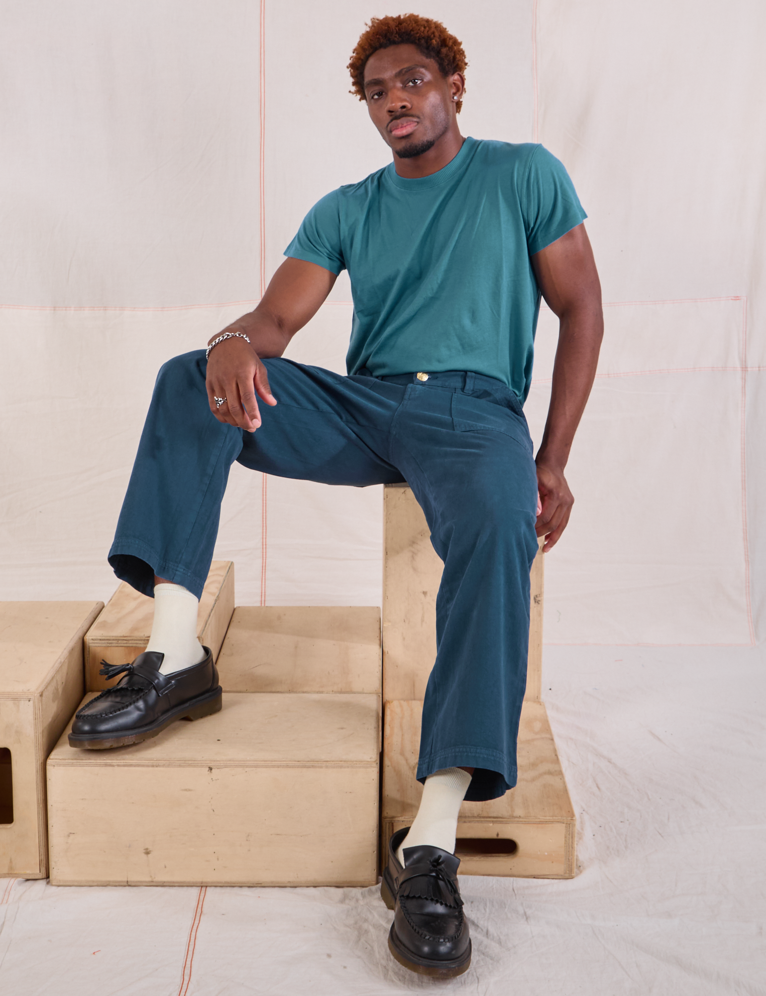 Issac is wearing Mid-Rise Work Pants in Lagoon and marine blue Organic Vintage Tee