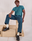 Issac is wearing Mid-Rise Work Pants in Lagoon and marine blue Organic Vintage Tee