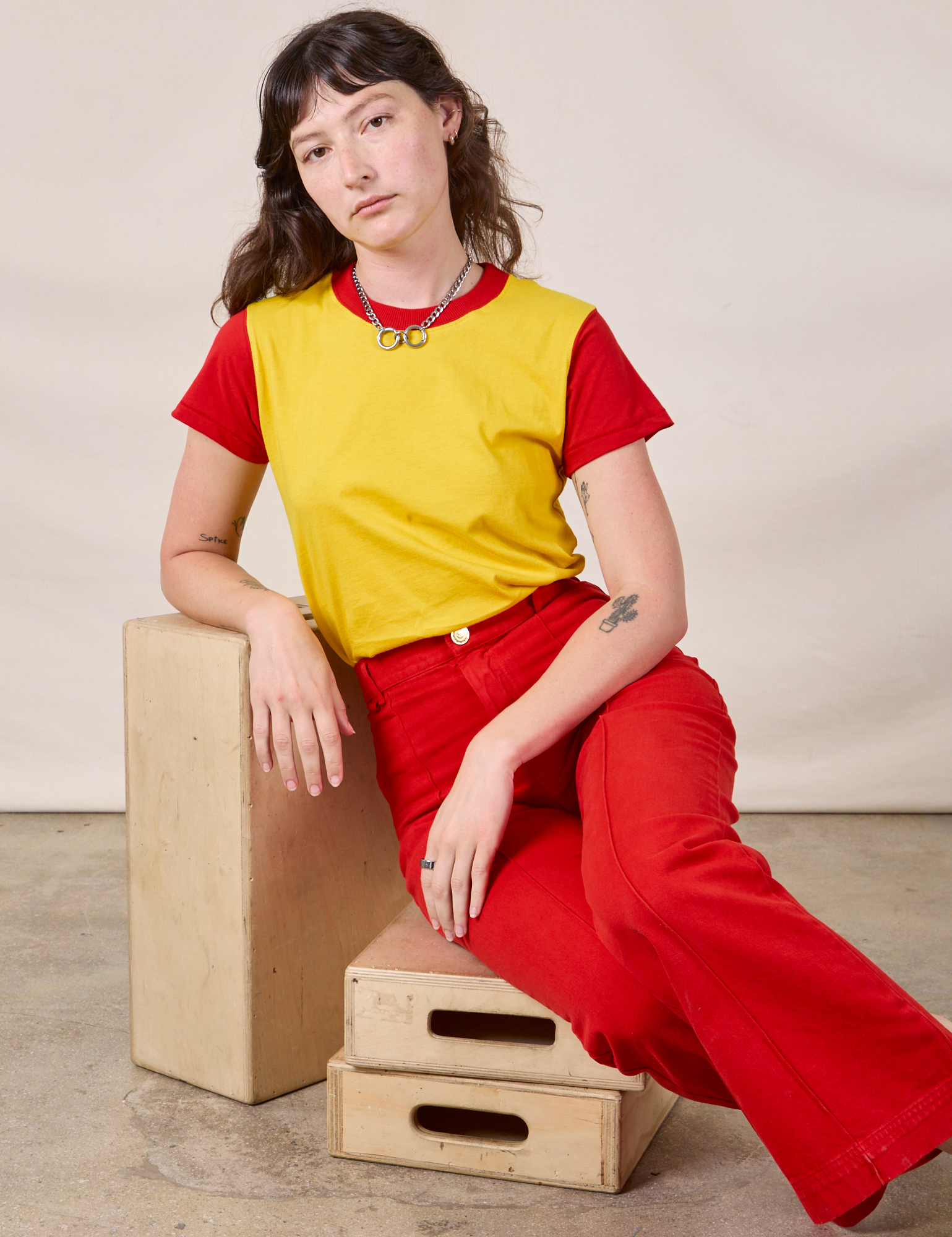 Mismatched Tee in Yellow &amp; Red and mustang red Western Pants worn by Alex