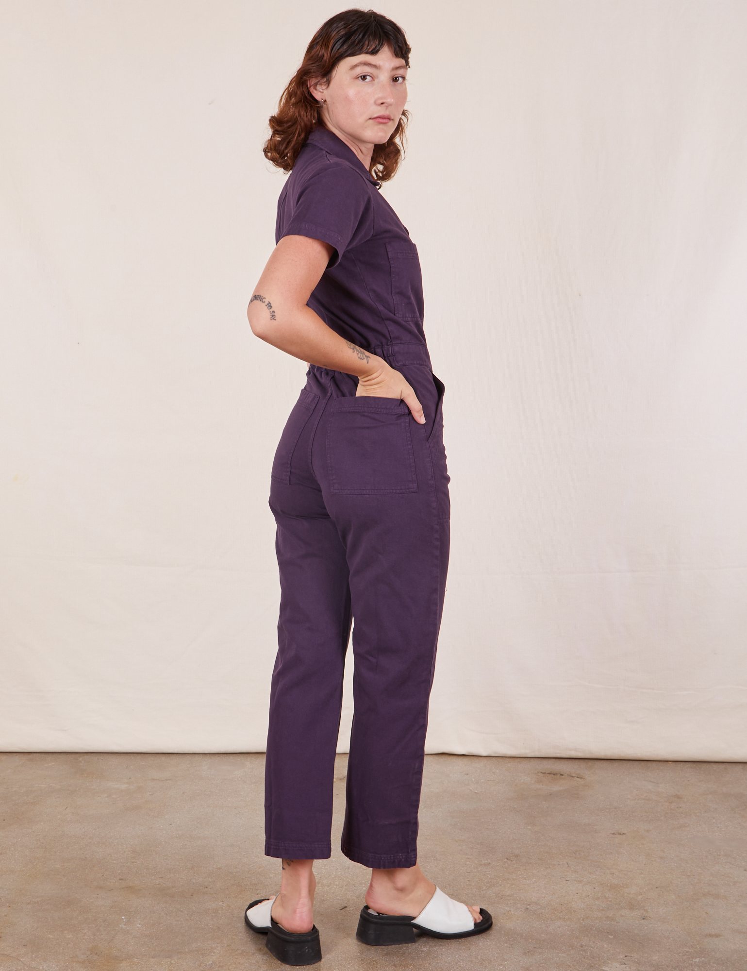 Angled back view of Short Sleeve Jumpsuit in Nebula Purple worn by Alex