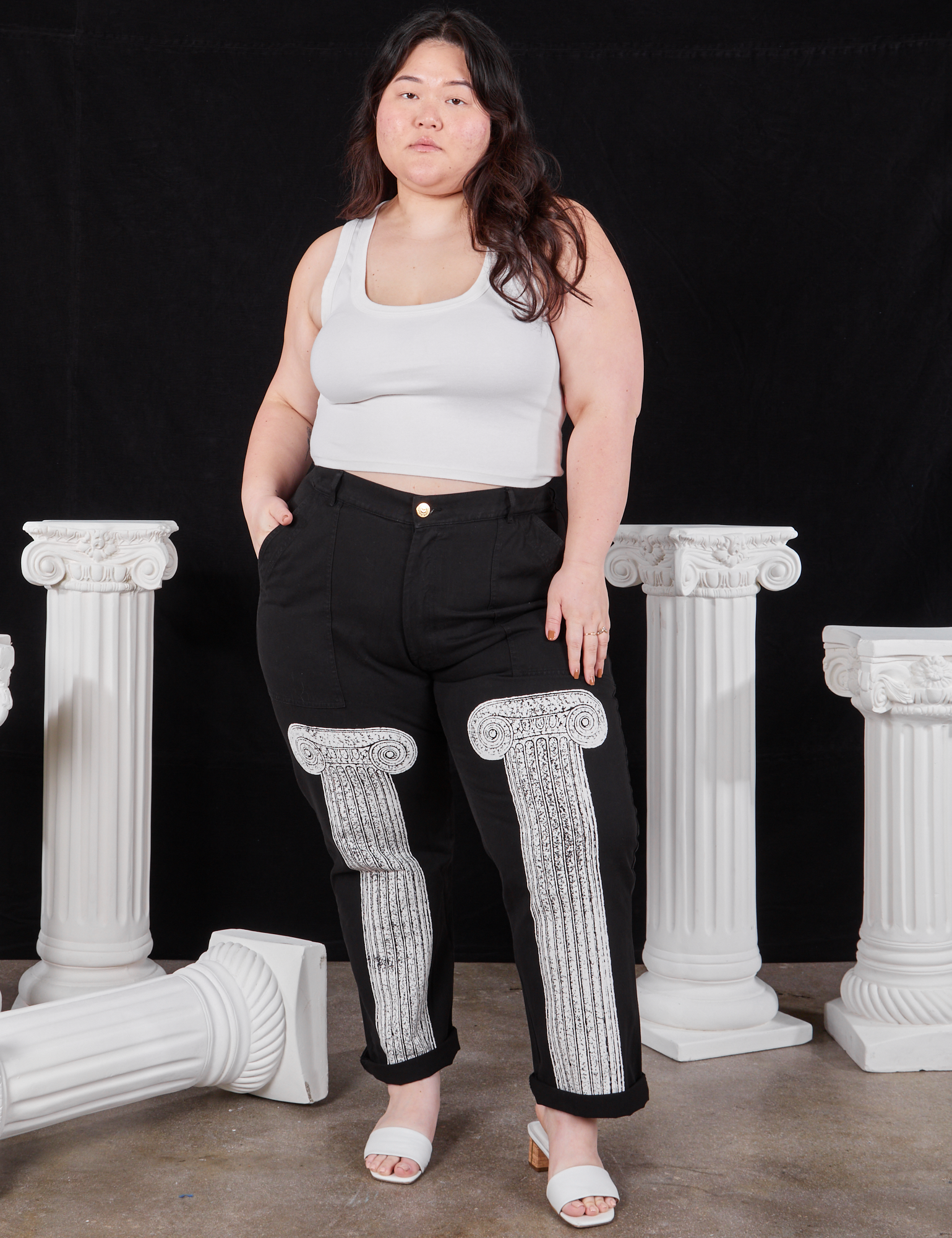 Ashley is 5&#39;7&quot; and wearing 1XL Column Work Pants in Basic Black paired with vintage off-white Cropped Tank Top