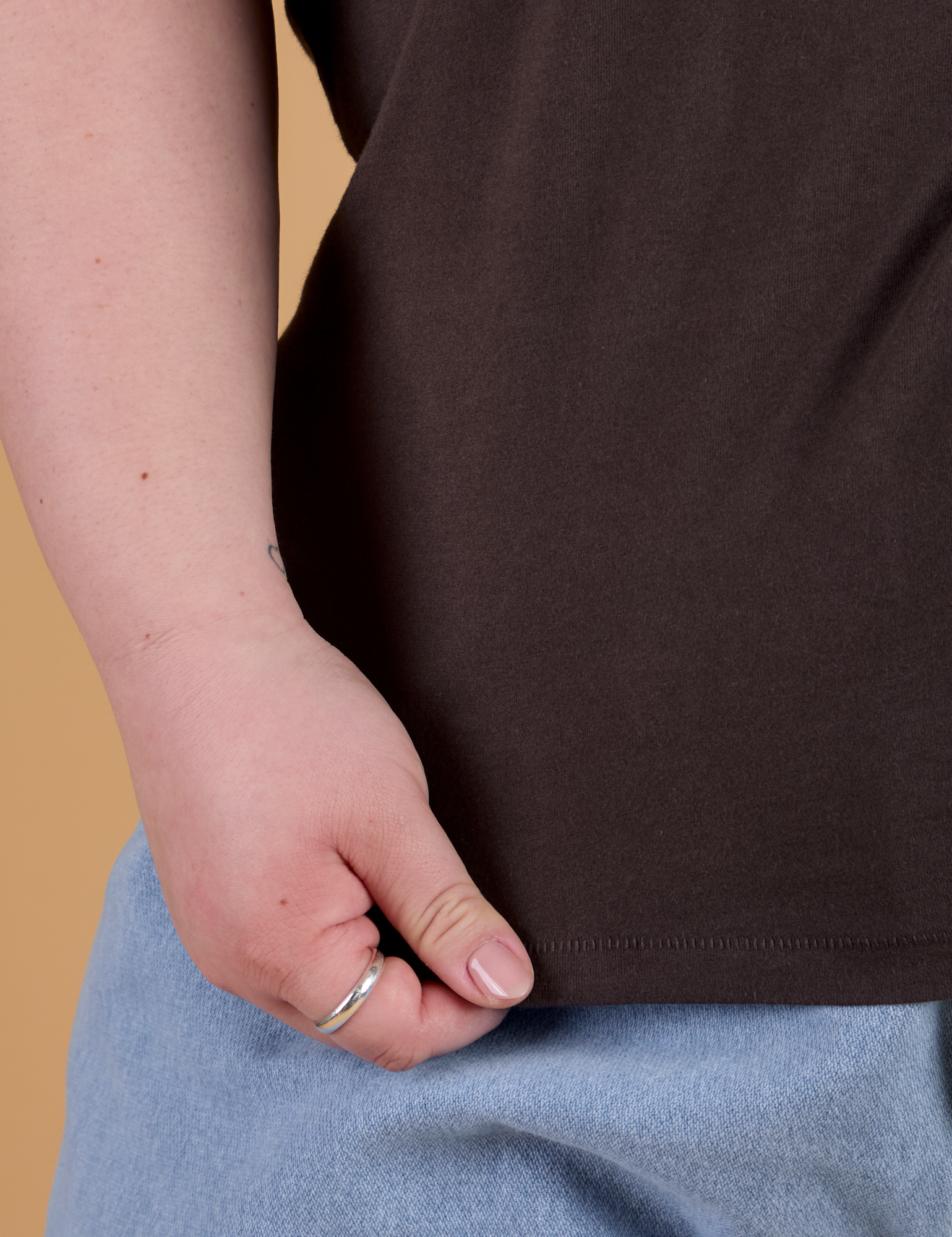 Bottom close up of Organic Vintage Tee in Espresso Brown with Ashley holding hem