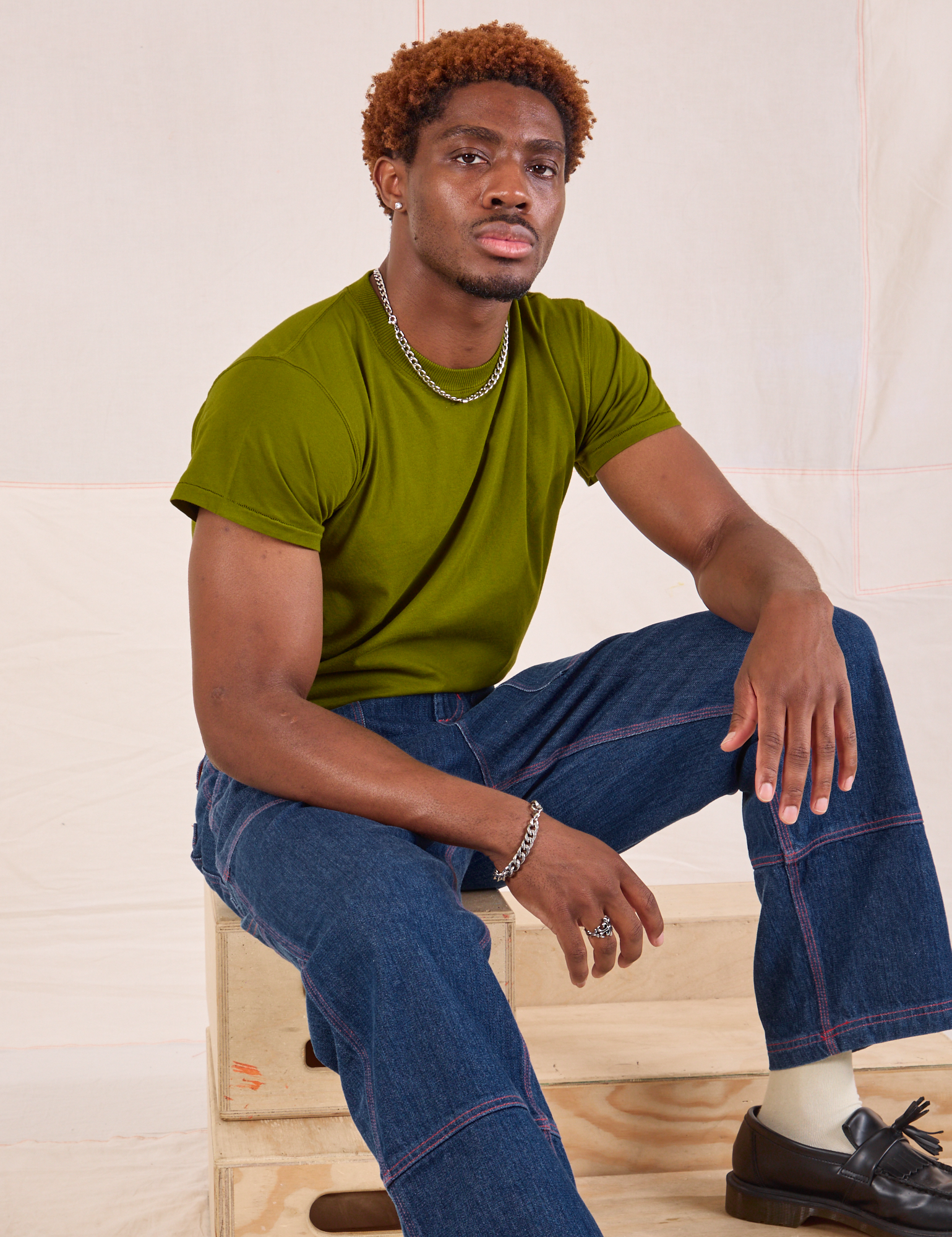 Issac is wearing Organic Vintage Tee in Summer Olive and dark wash Carpenter Jeans