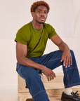 Issac is wearing Organic Vintage Tee in Summer Olive and dark wash Carpenter Jeans