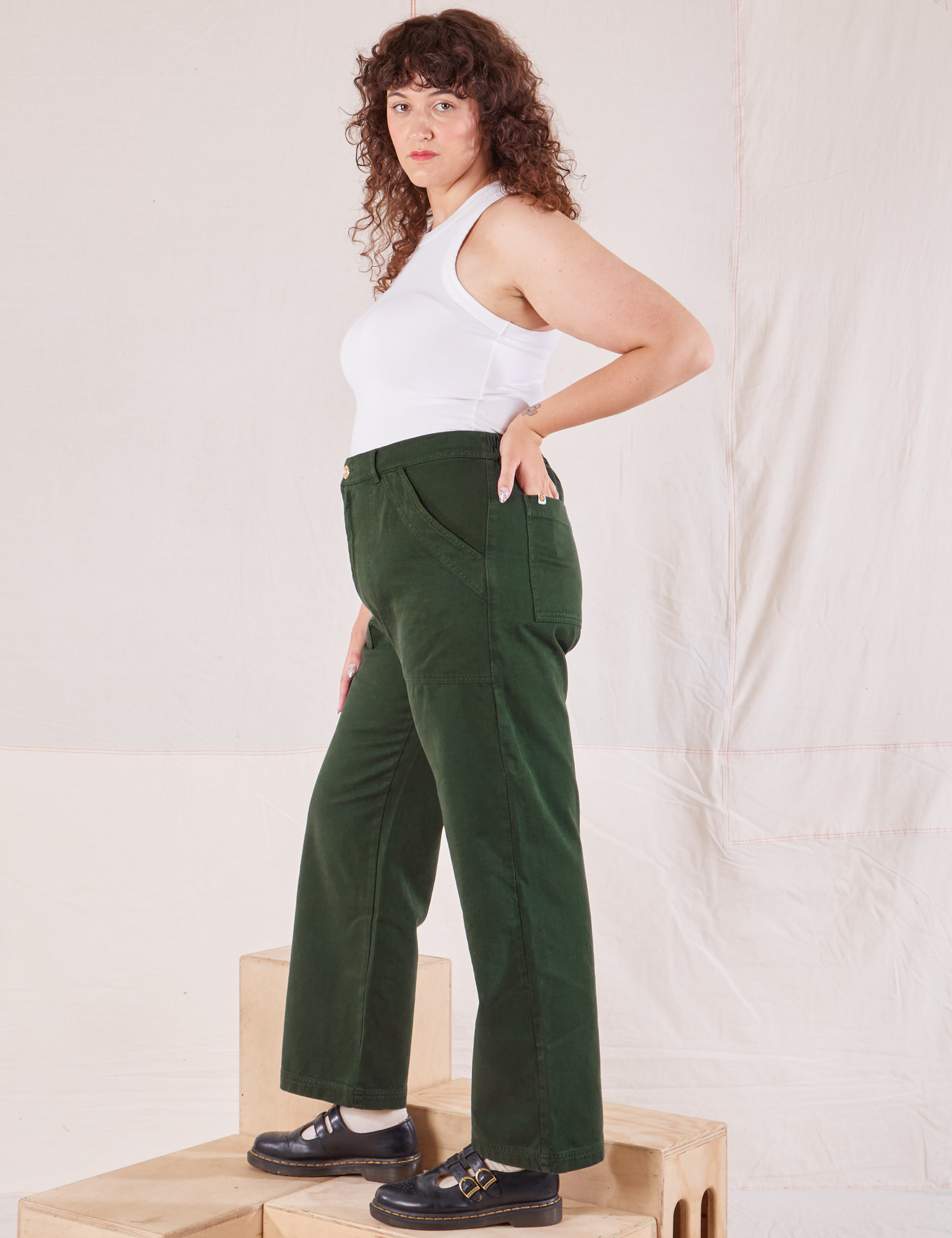 Side view of Organic Work Pants in Swamp Green and Racerback Tank in vintage tee off-white on Ryan