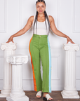 Gabi is and wearing S Hand-Painted Stripe Western Pants in Bright Olive paired with a vintage off-white Tank Top