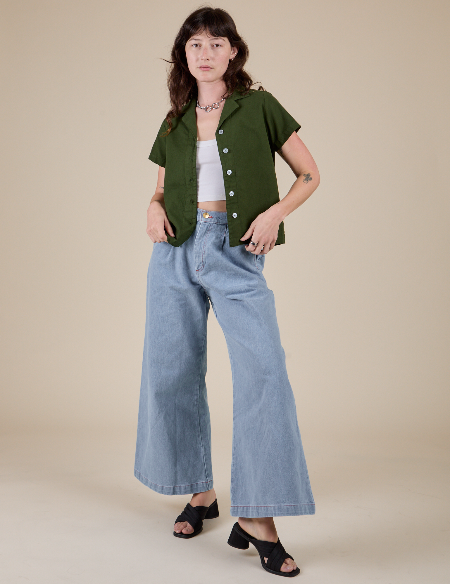 Alex is wearing Pantry Button-Up in Evergreen and light wash Indigo Wide Leg Trousers